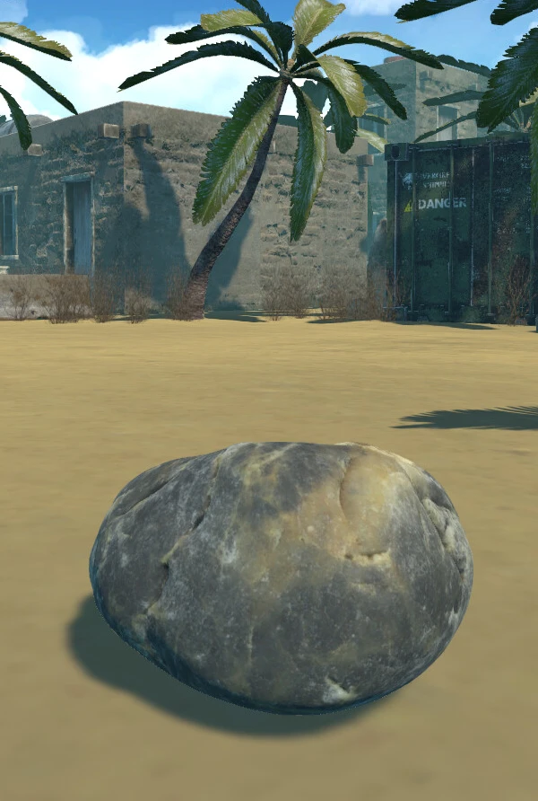 A rock on a sandy island beside a damaged building and palm tree.
